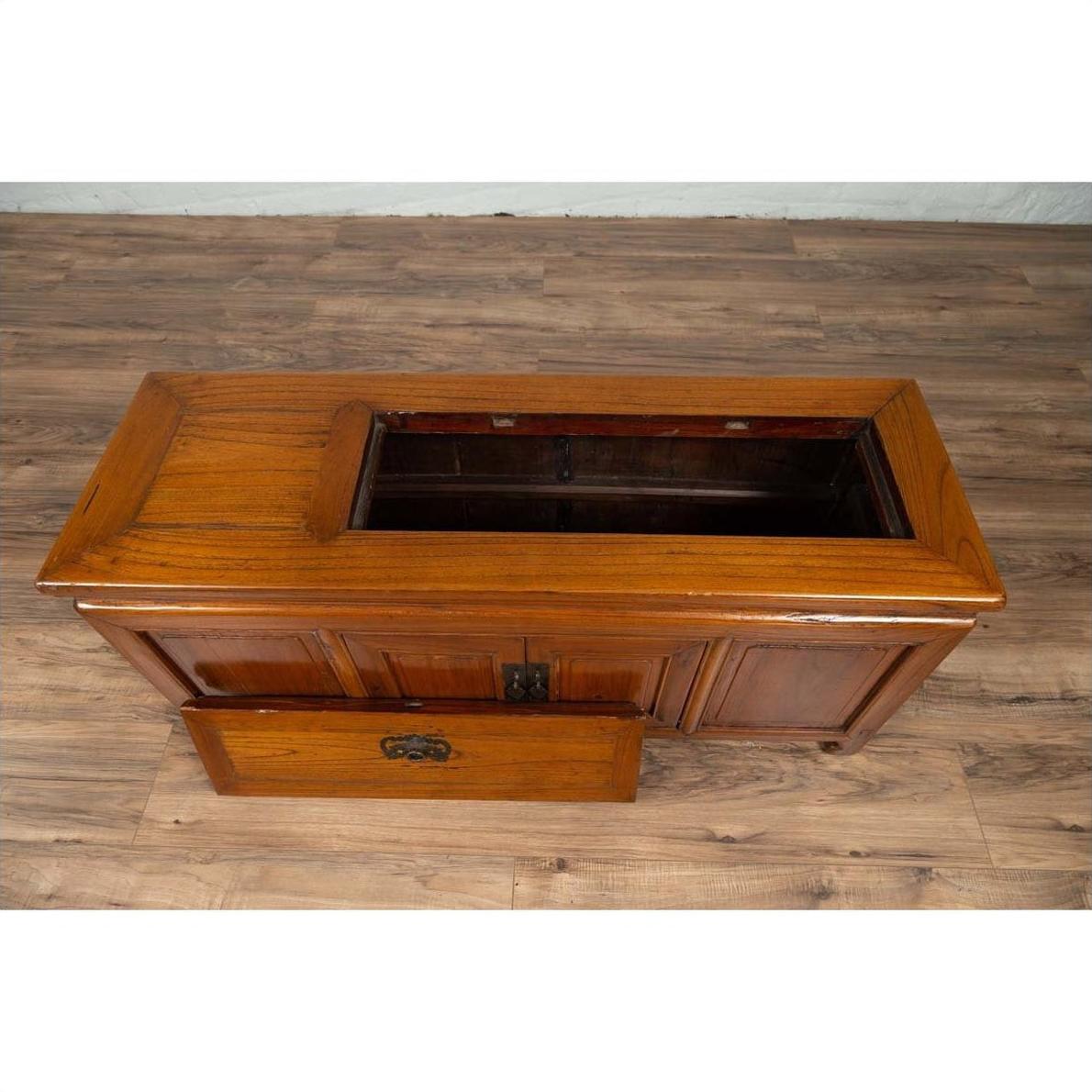 Brown wood two-door buffet with faux doors and removable upper panel, placed on a wooden floor indoors.
