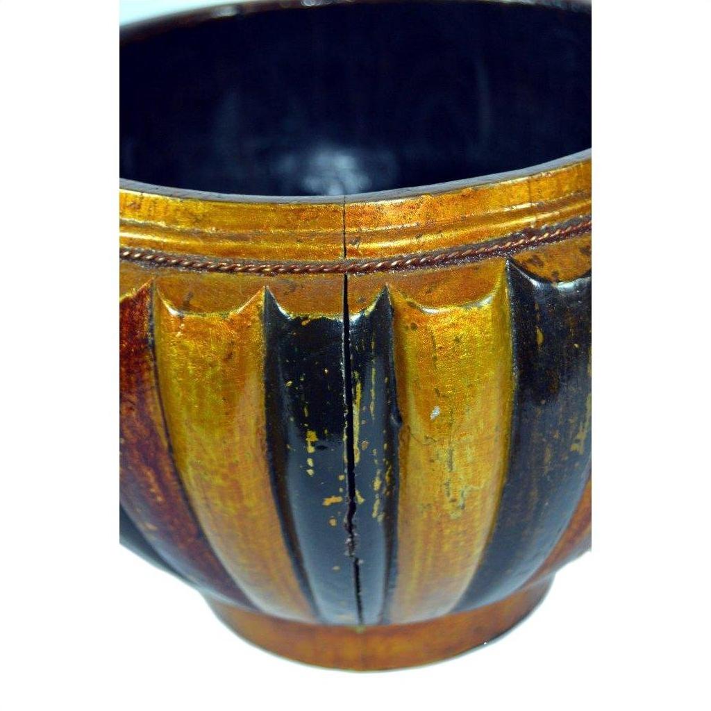 Close-up of round, fluted brown-gold bamboo rice basket with shiny finish and visible cracked body.