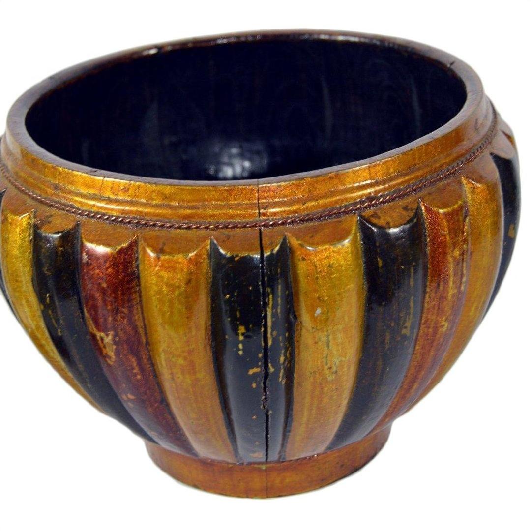 Close-up of a round bamboo rice basket with gold, brown, and black stripes, ribbed texture, and cracked glossy finish.