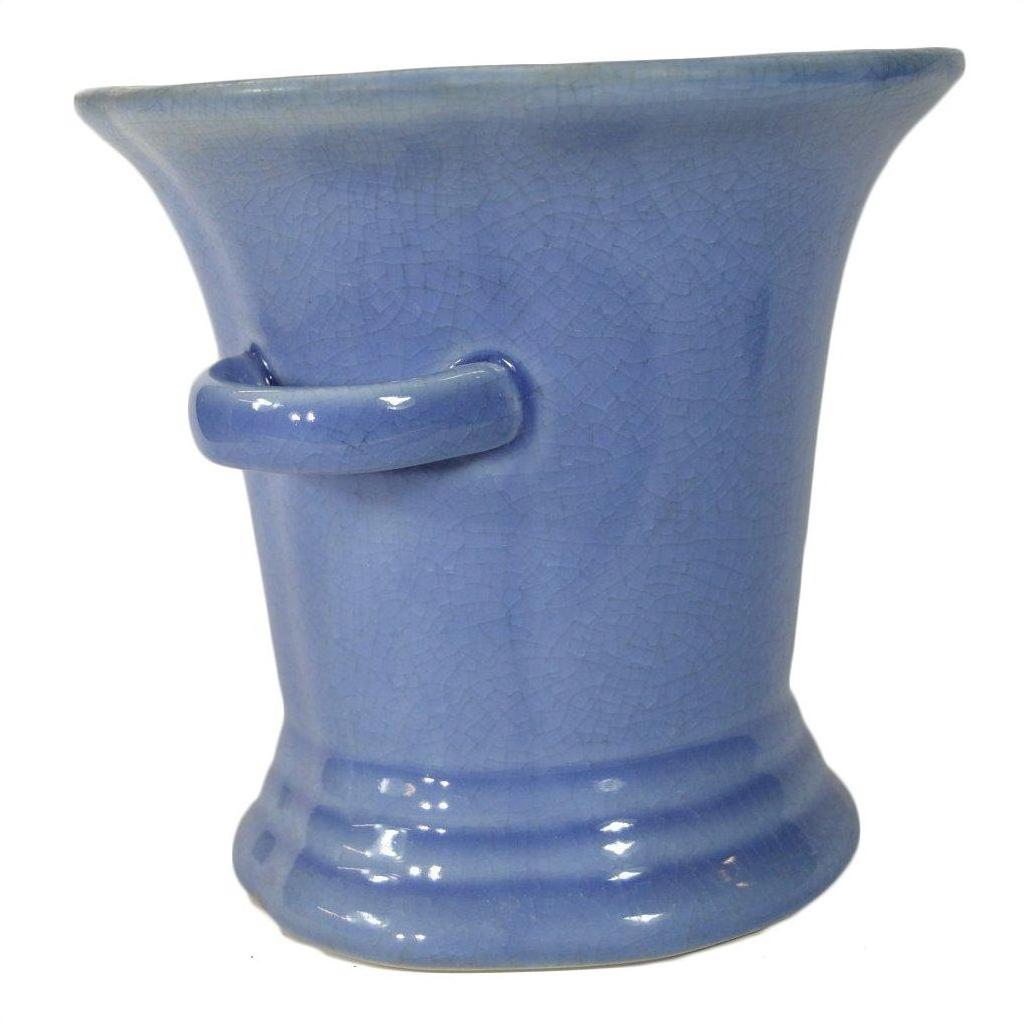Close-up of blue celadon porcelain planter with flared rim, side handle, and crackle glaze.