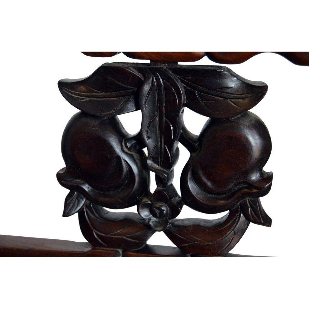 Close-up of dark wood carving showing peaches, leaves, and a flower from a Chinese rosewood chair, early 20th century.