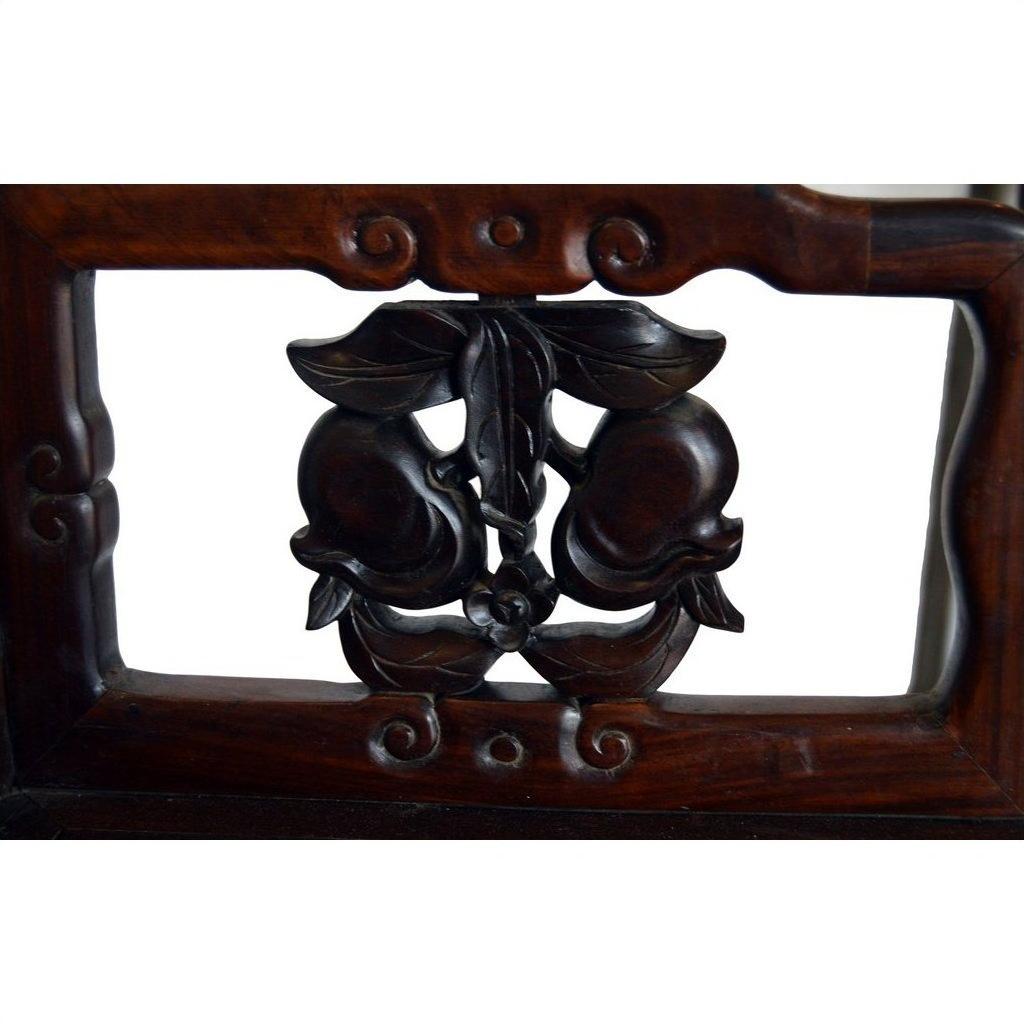 Close-up of carved dark wood peaches and leaves detail on Early 20th Century Chinese rosewood chair.