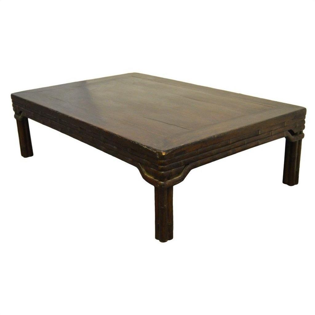 Dark wood Chinese coffee table with rectangular top, carved friezes, and four short legs on white background.