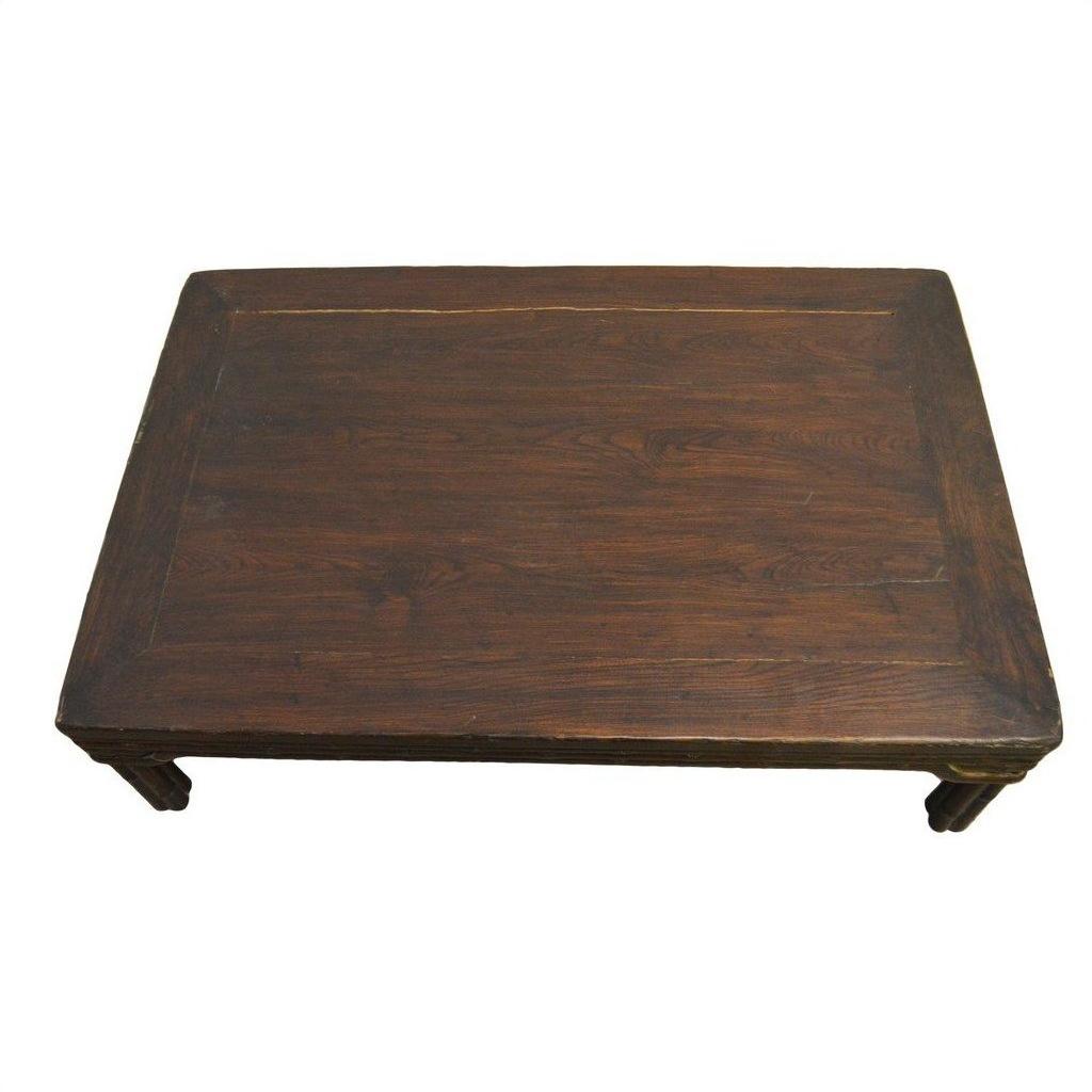 Rectangular dark wood Chinese coffee table with carved friezes and four legs on a white background.