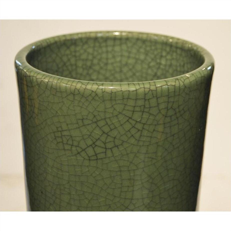 Close-up of pale green crackle celadon porcelain vase, viewed from top and side, against plain background.