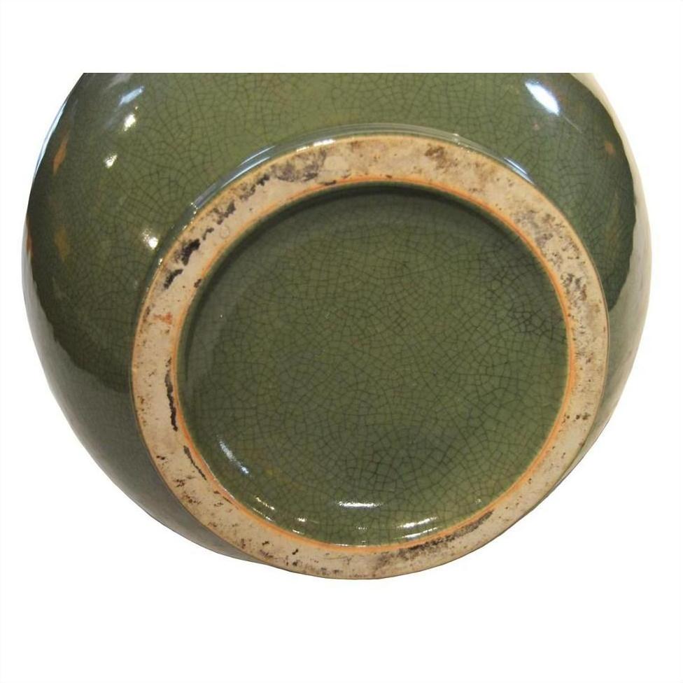 Close-up of base of Chinese crackle celadon porcelain vase, showing crackled glaze and lightly worn unglazed rim.