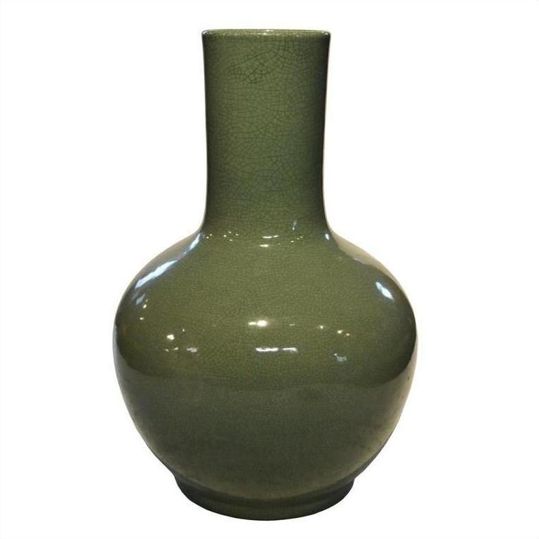 Glossy green celadon porcelain vase with crackle texture, round body, and tall narrow neck on white background.