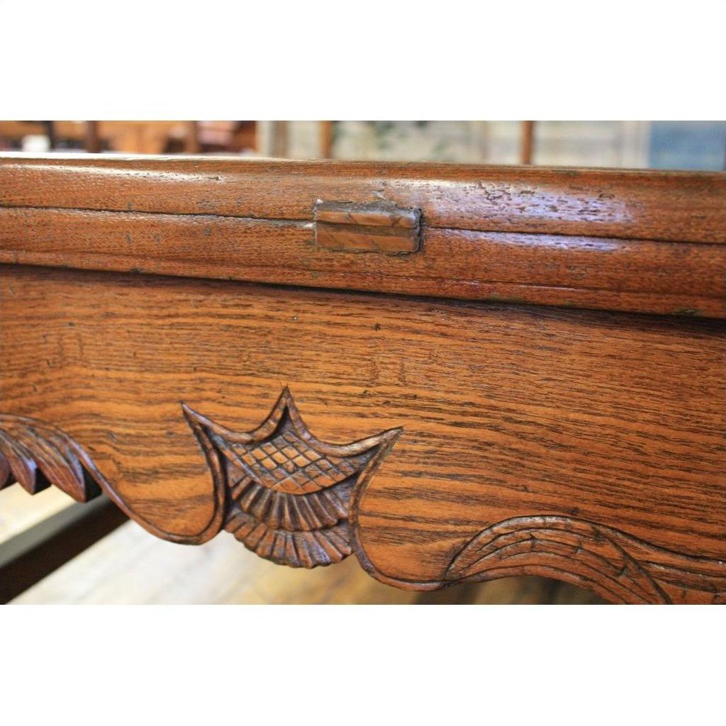 Close-up of dark wood Chinese daybed edge with ornate carvings and a small metal hinge.