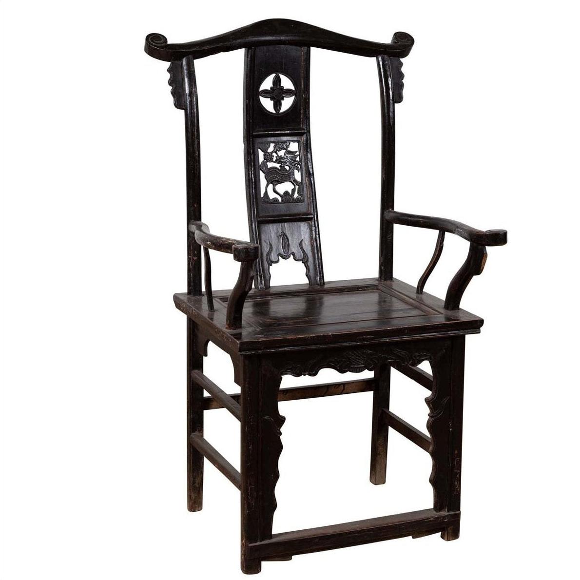 Dark patina elmwood chair with ornate carvings and rectangular seat, indoor setting.