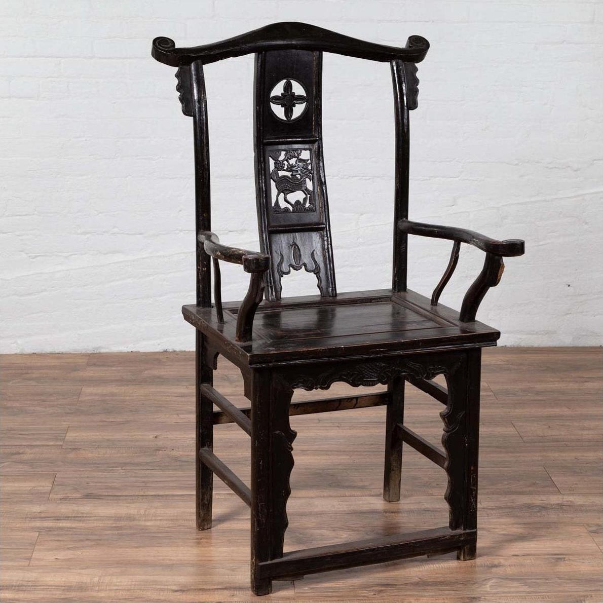 Dark patina elmwood scholar's chair on wood floor with white brick wall background.