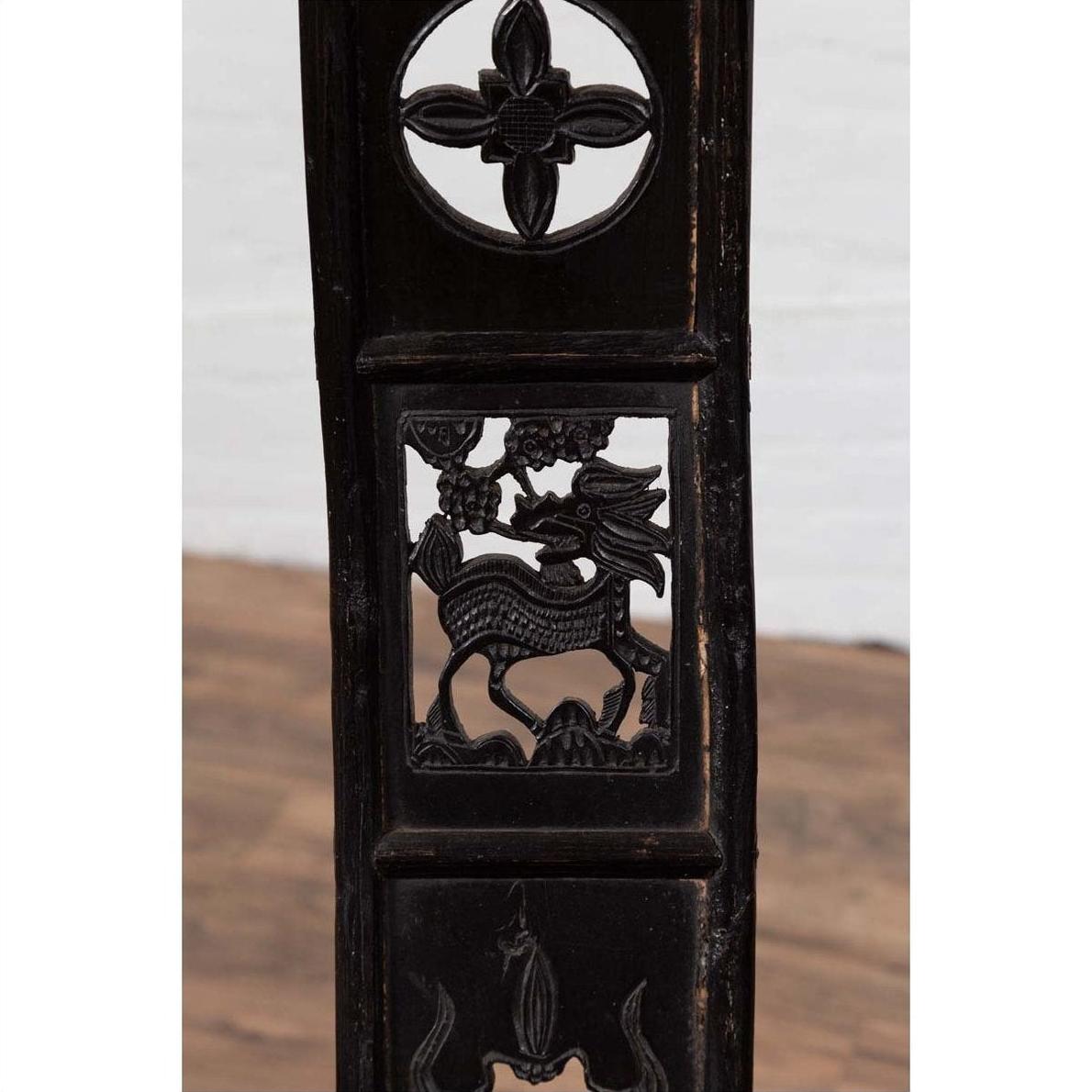 Dark patina elmwood chair with dragon and floral carvings, inspired by 19th century Chinese design, indoor setting.