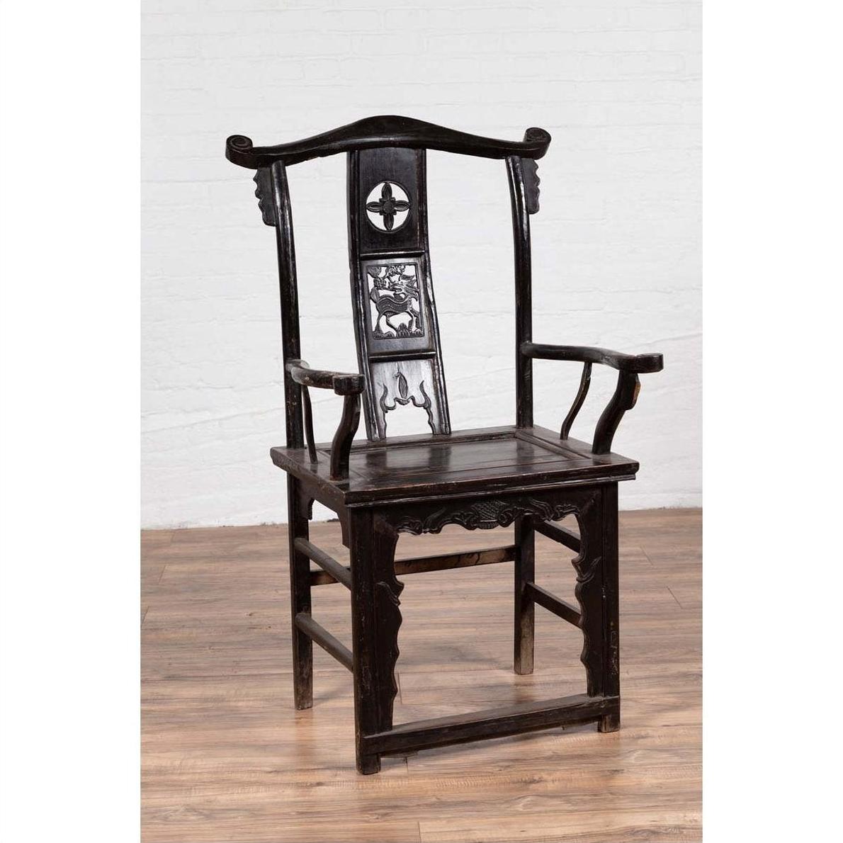 Dark patina elmwood scholar's chair set on wooden floor against a white brick wall indoors.