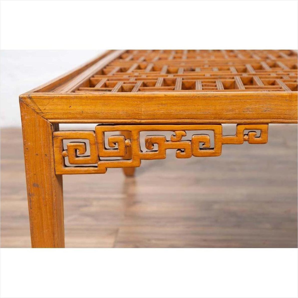 Close-up of dark wood square coffee table corner with open fretwork detail and curved horse-hoof legs.
