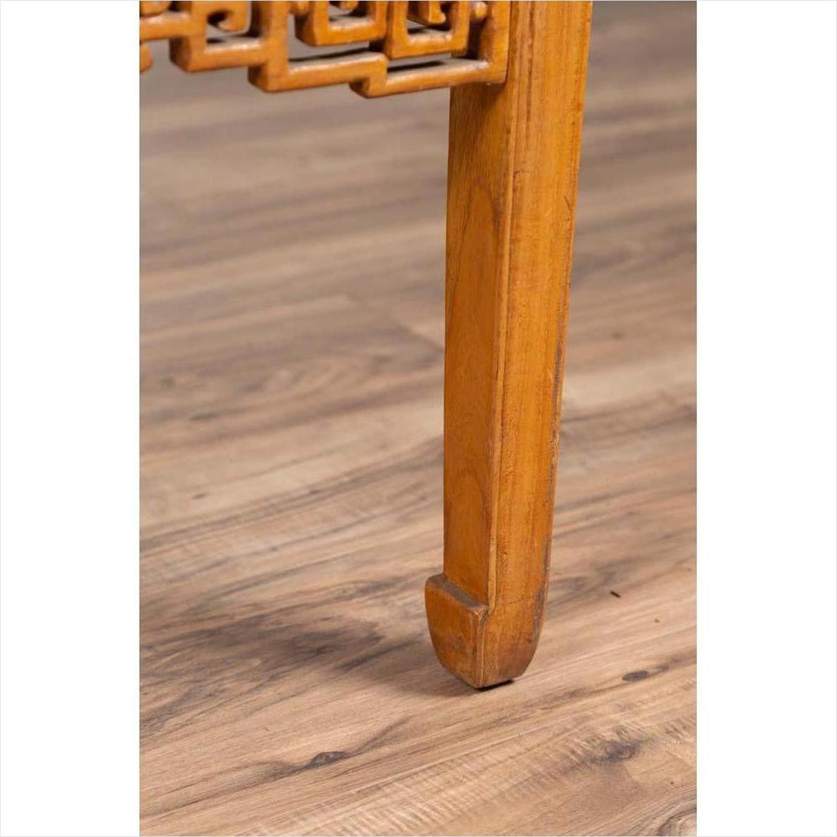Close-up of brown elmwood square coffee table with horse-hoof legs on light brown wood floor indoors.