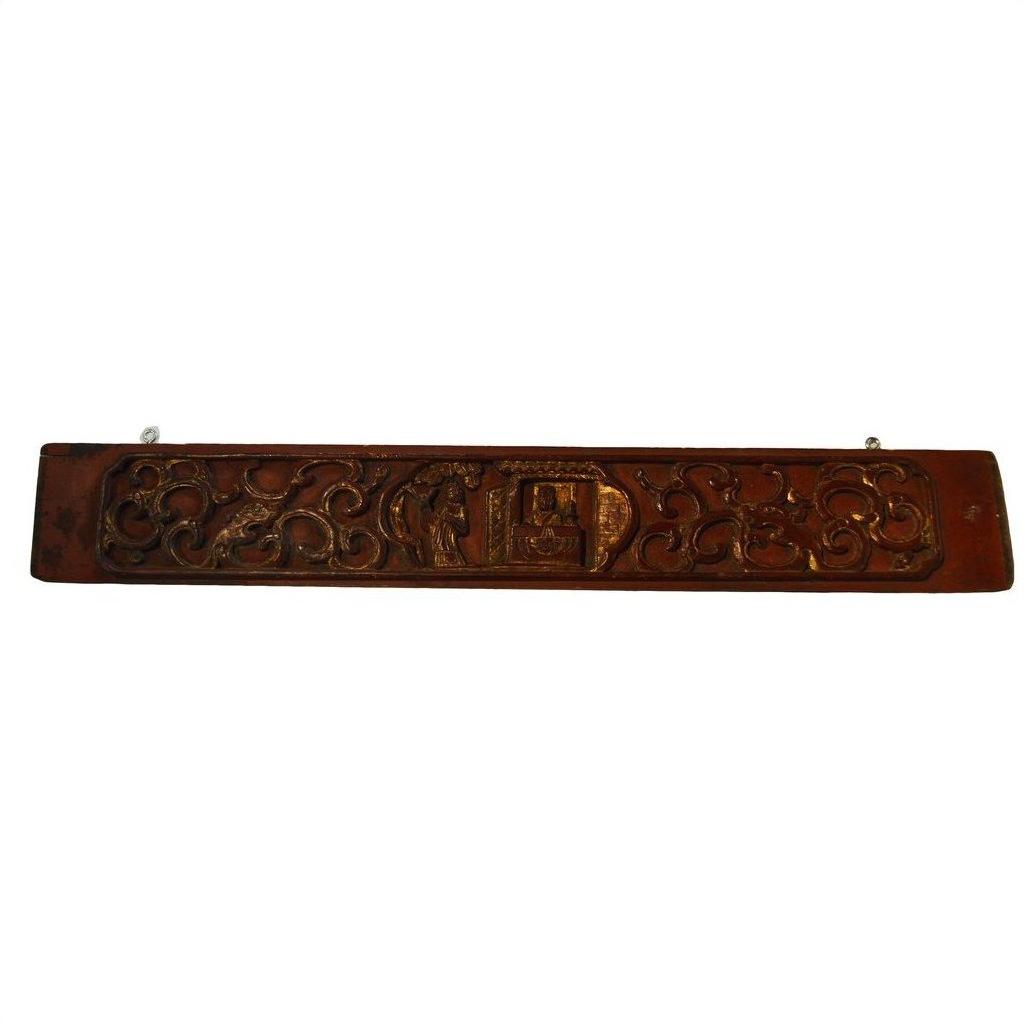 Brown carved wood plaque with swirling patterns and a rectangular center on a plain white background.