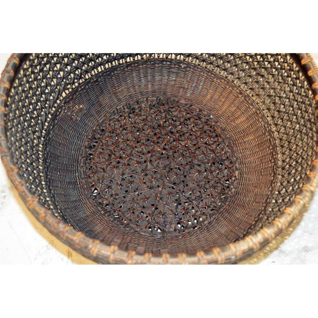 Red Chinese lacquered bamboo basket with intricate pattern on base and sides, top view, empty.