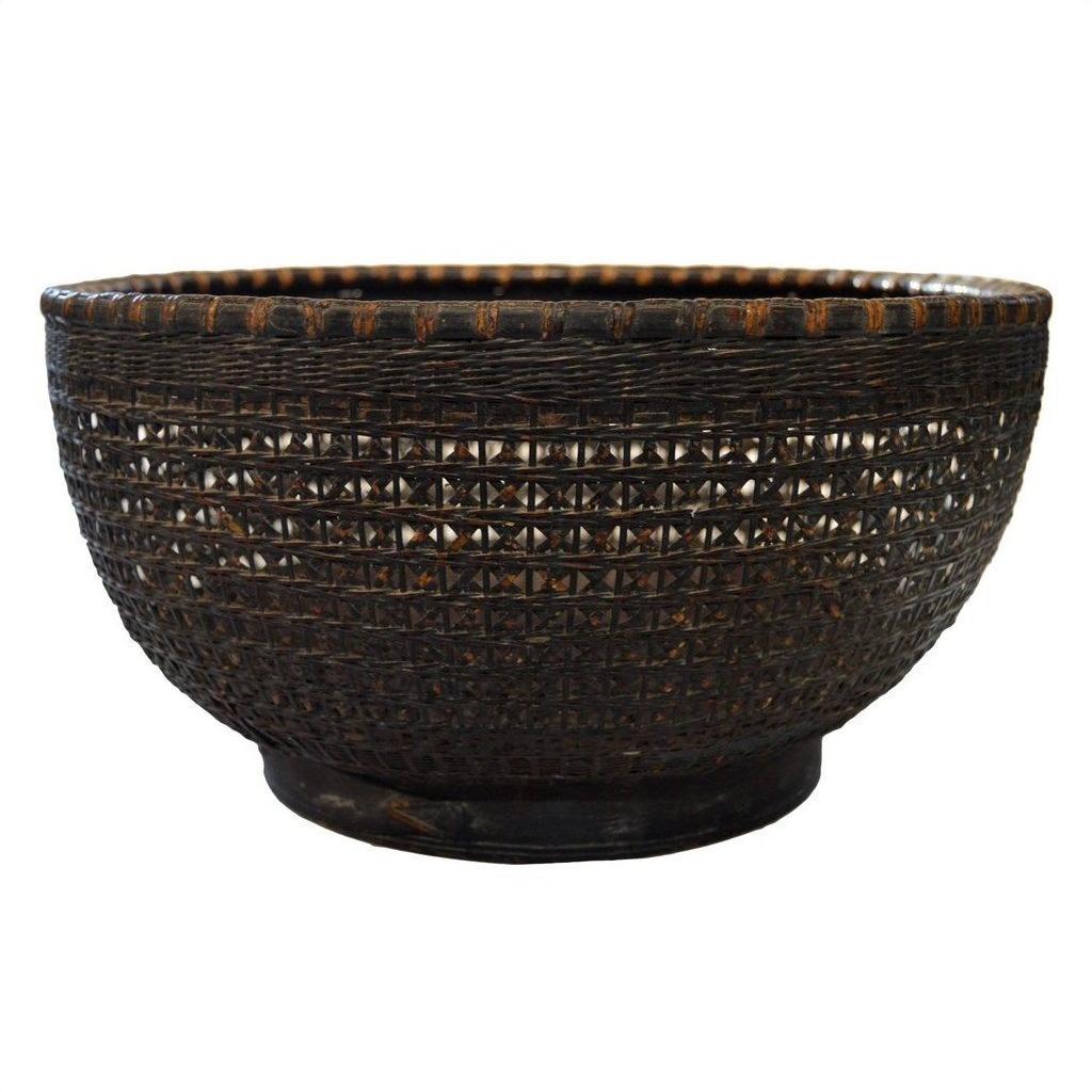 Dark brown lacquered bamboo basket with wide opening and textured, patterned sides, close-up view.