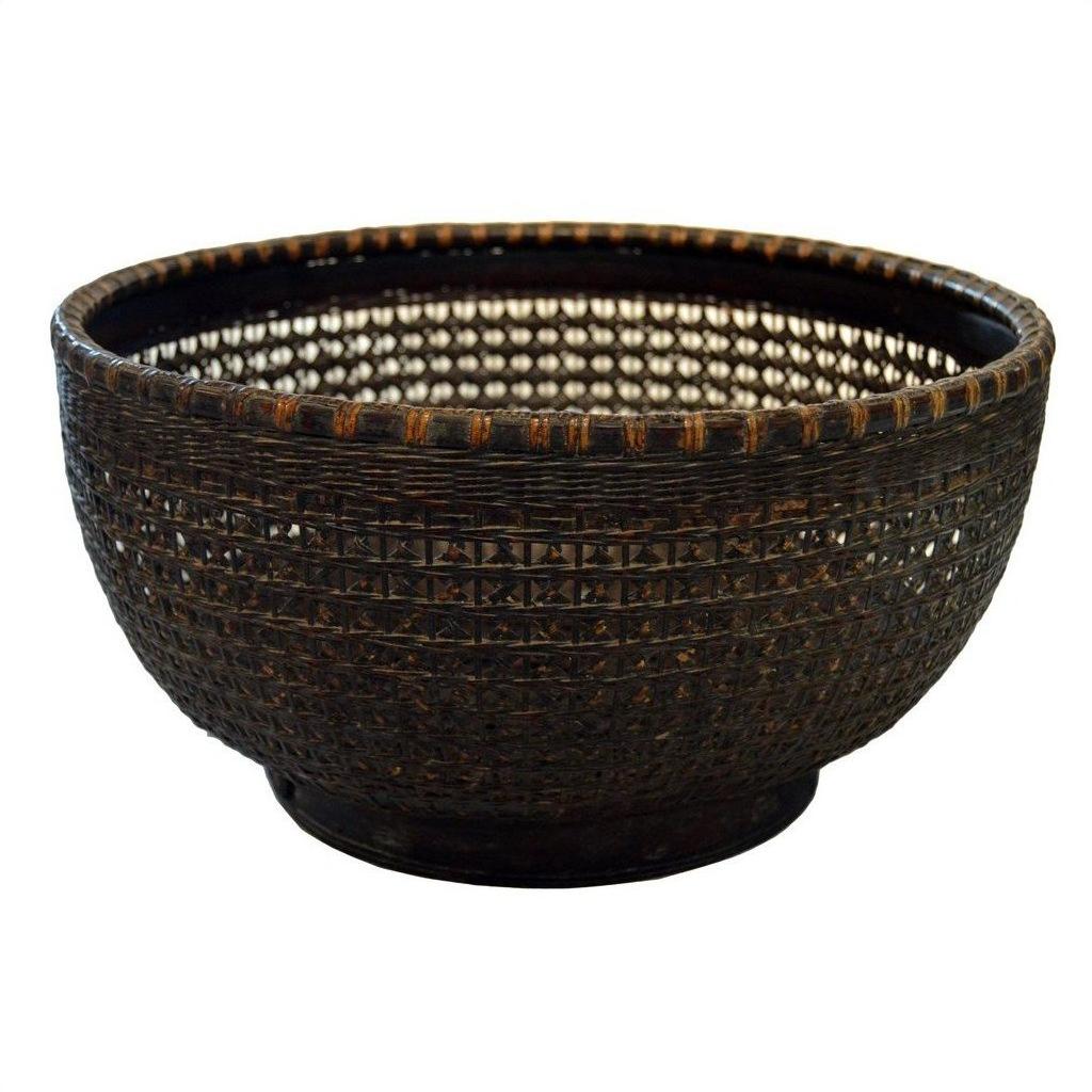Close-up of a round, dark brown lacquered bamboo basket with wide opening and textured woven sides.