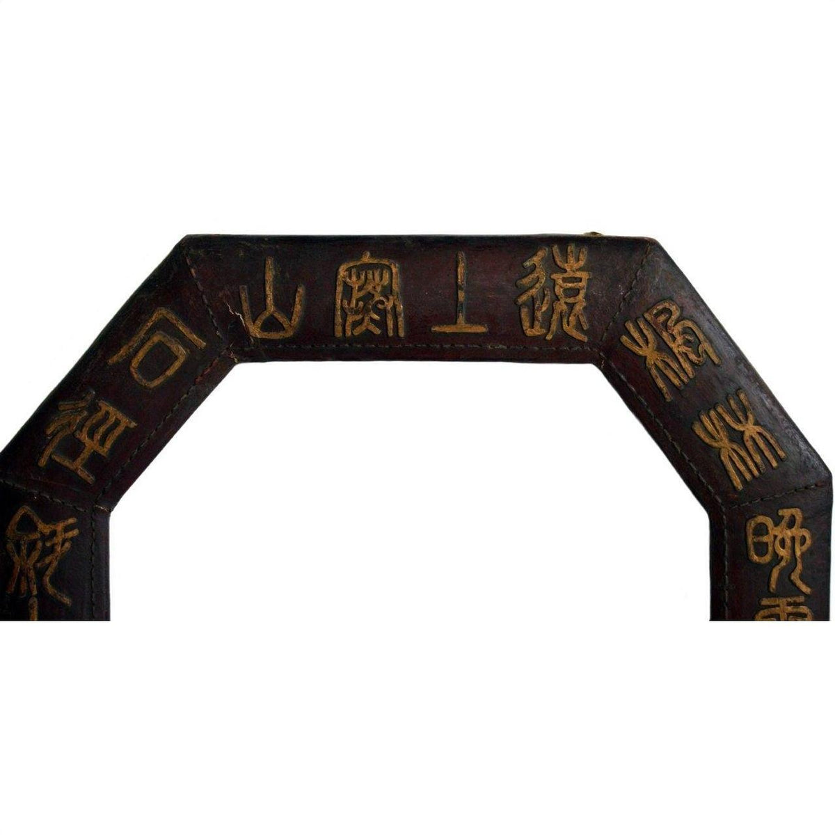 Close-up of vintage dark wood octagonal leather frame with gold Chinese calligraphy on upper section.