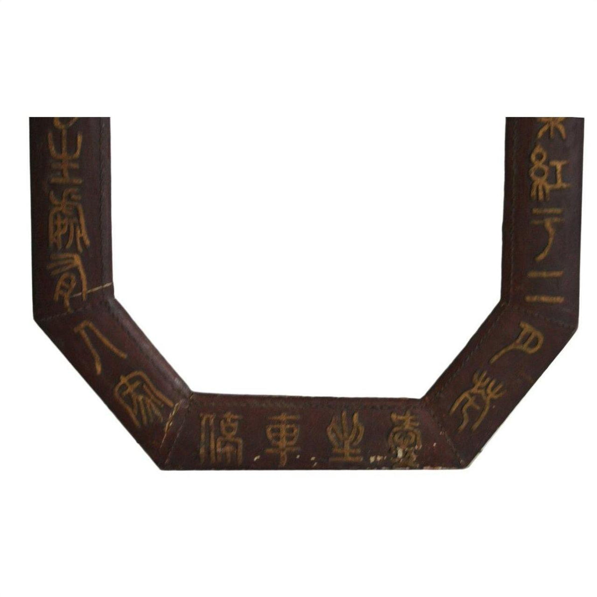Close-up of a dark brown leather octagonal frame with gold calligraphy on its surface.