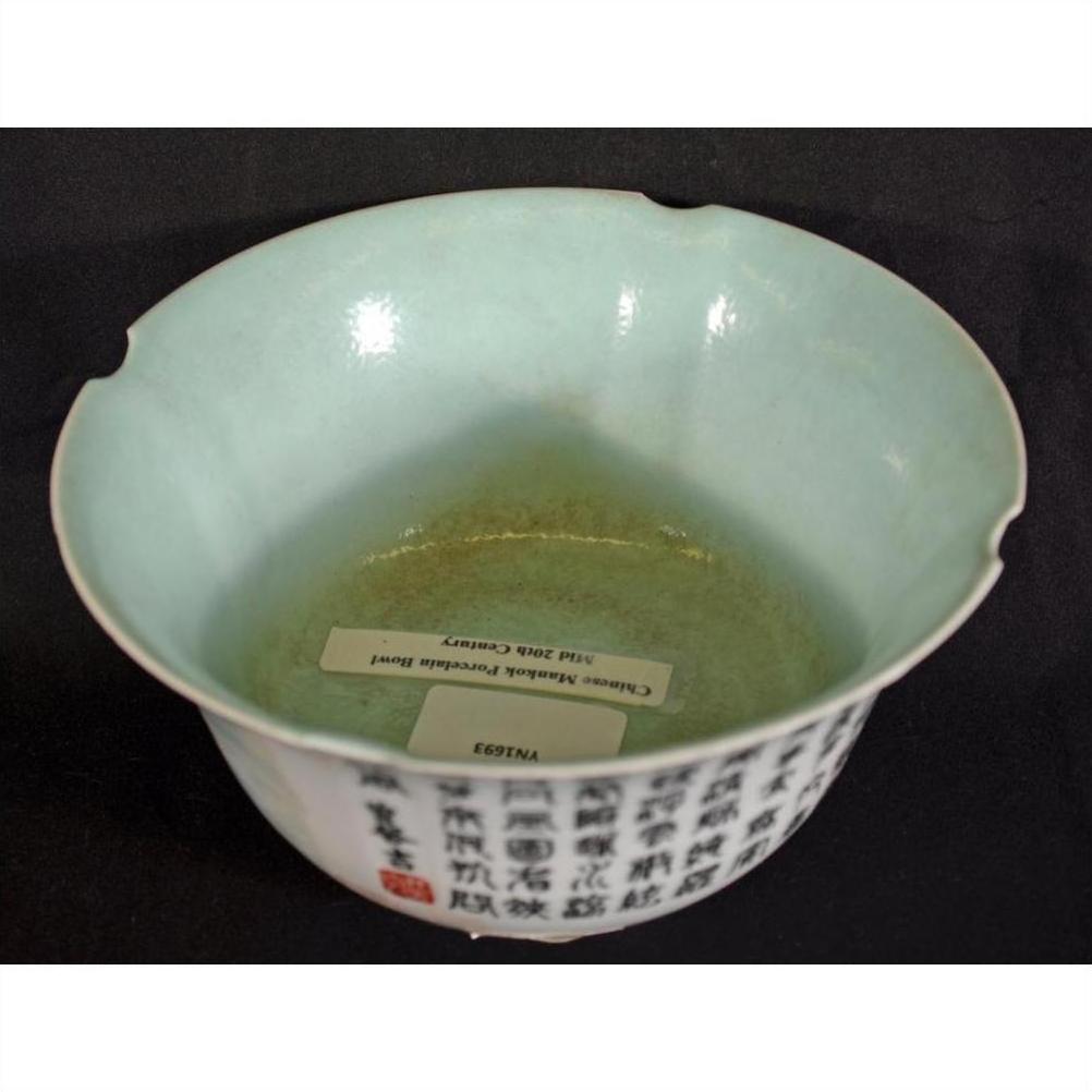 Pale green porcelain bowl with black script and two labels inside, on a black background.