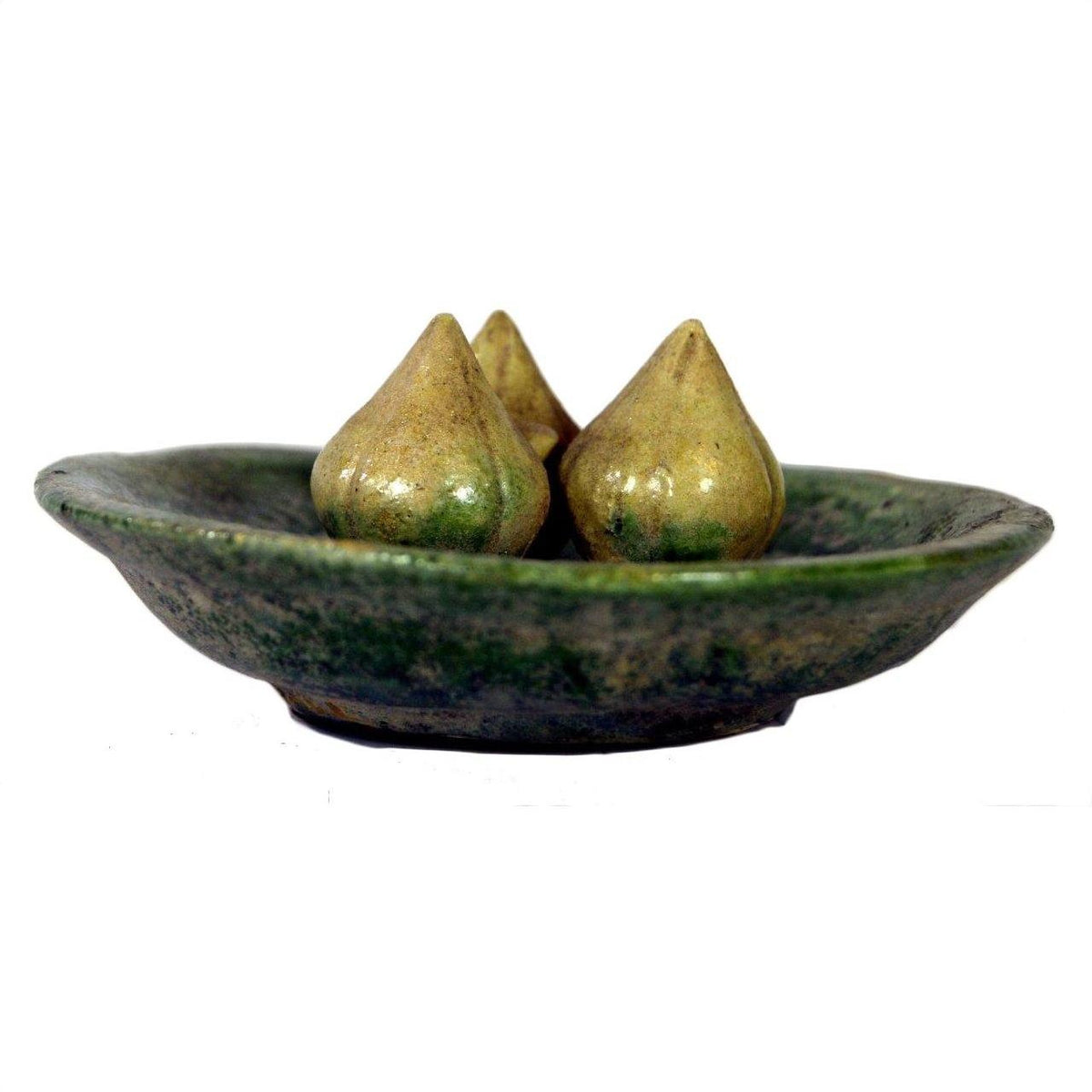 White ceramic Ming Dynasty plate with three teardrop-shaped glazed objects, close-up view on plain background.