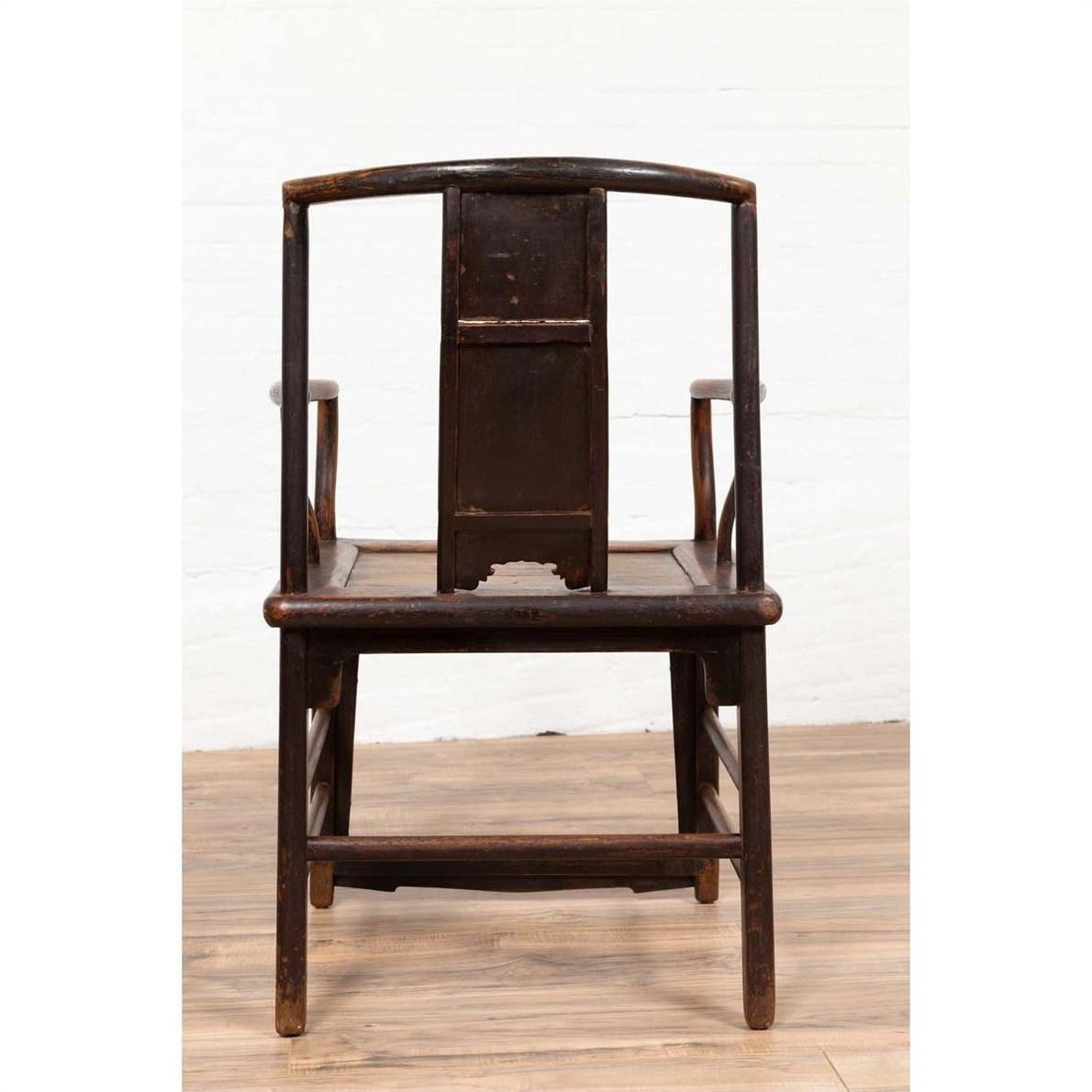 Brown elmwood chair with curved backrest on wooden floor, front view.
