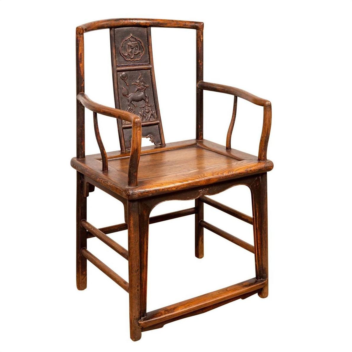 Brown elmwood chair with carved backrest and curved armrests, Ming Dynasty style, photographed indoors.