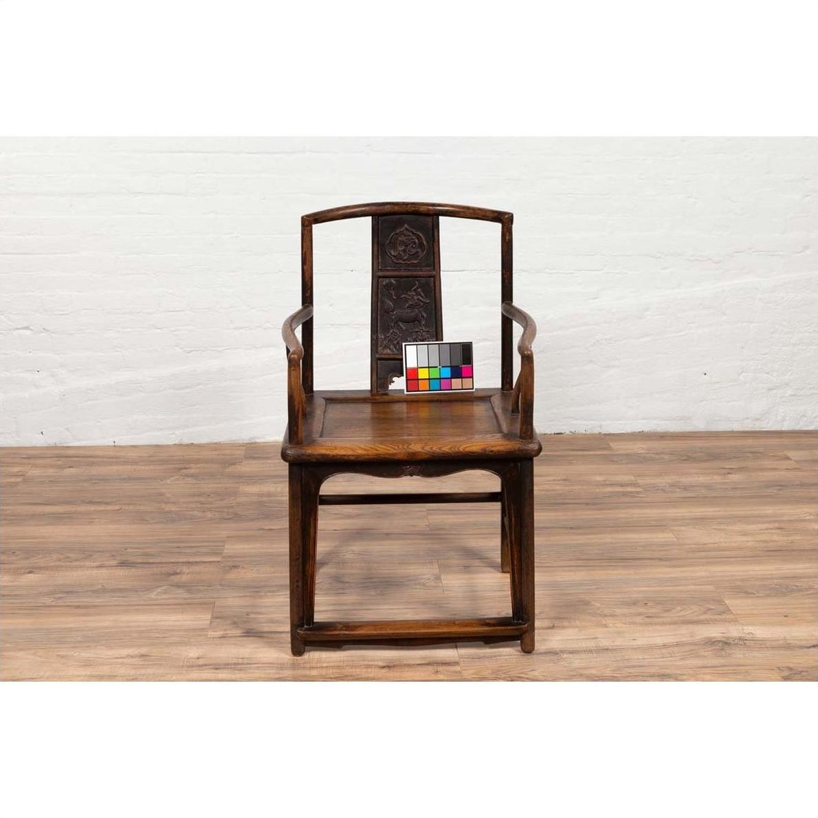 Brown elmwood Ming Dynasty Chinese wedding chair on wood floor indoors.