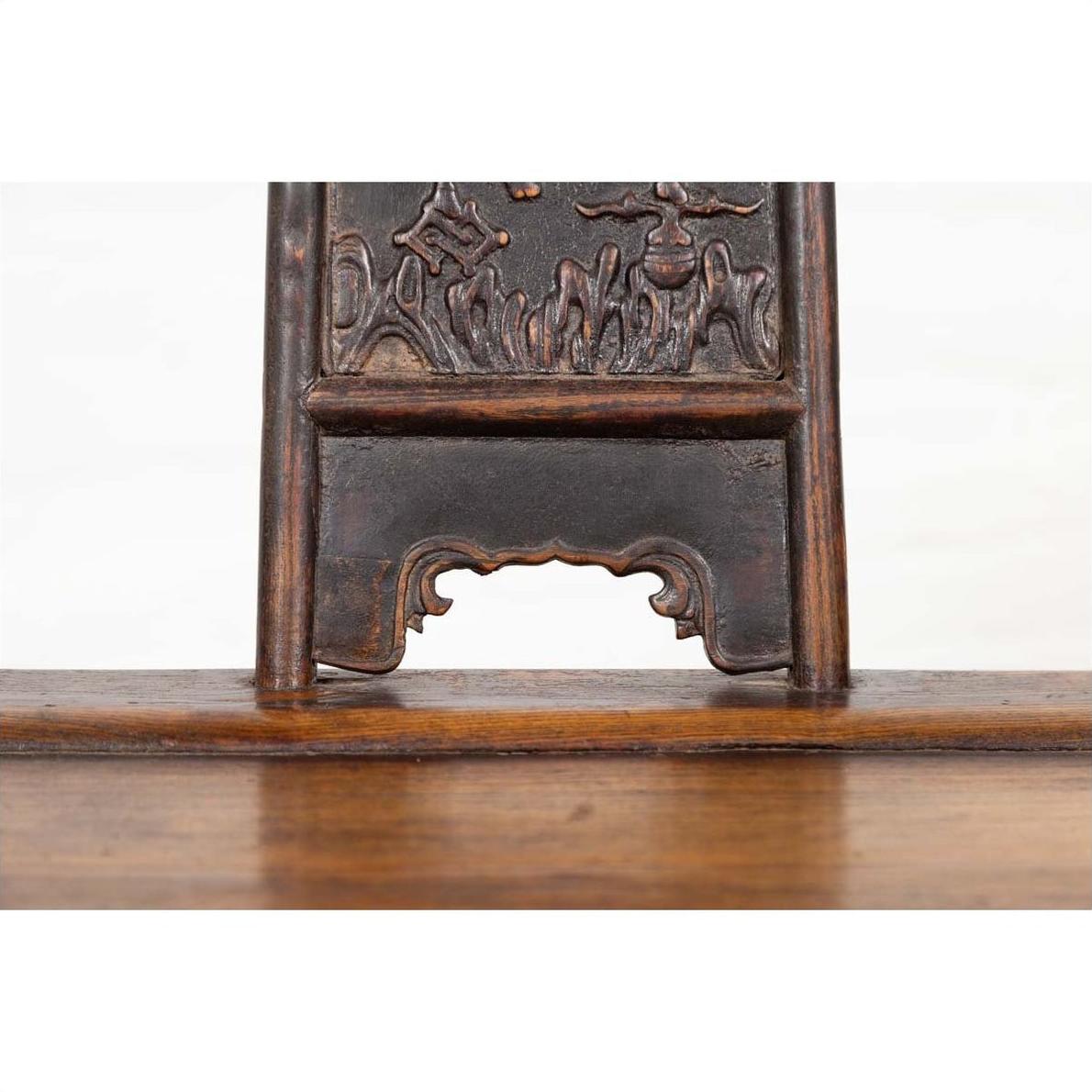 Close-up of ornately carved elmwood panel, dark brown wood, from Chinese Ming Dynasty chair.