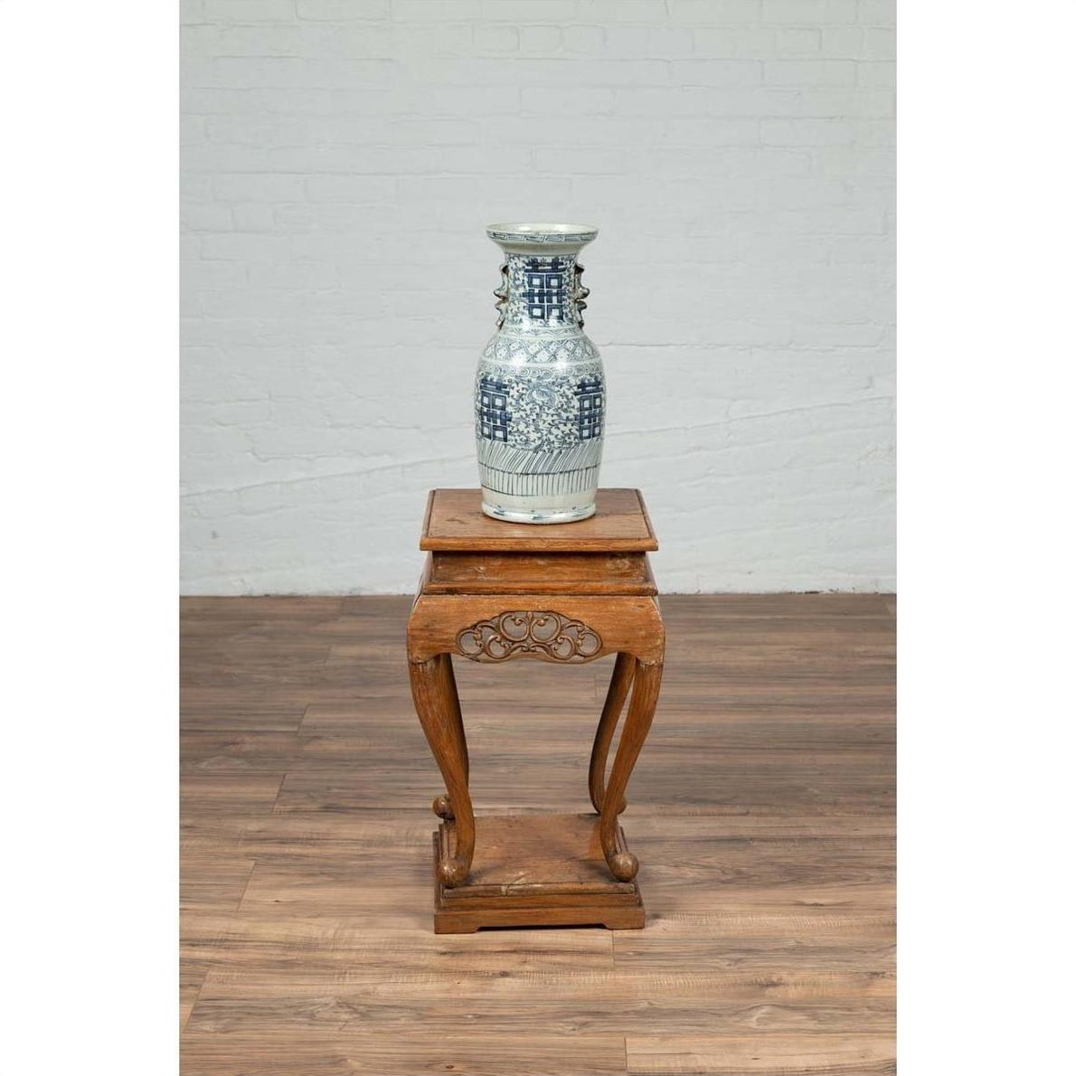 Blue and white ceramic vase on Chinese Ming style incense stand with cabriole legs and carved apron.