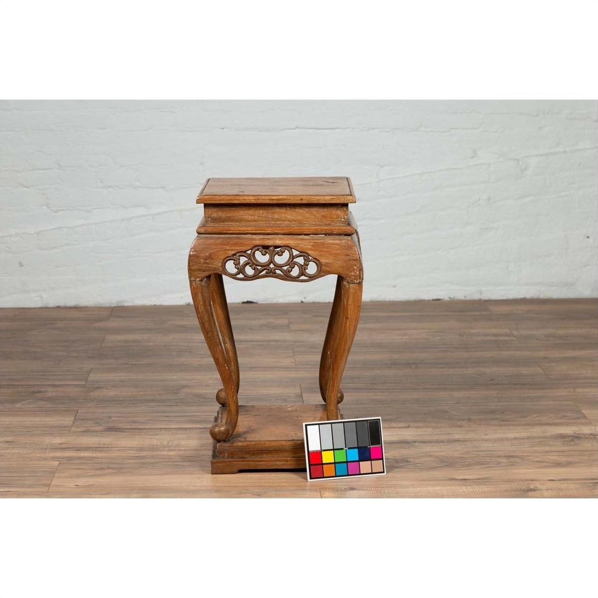 Brown wooden Ming style incense stand with cabriole legs and carved apron on wooden floor, chart in front.