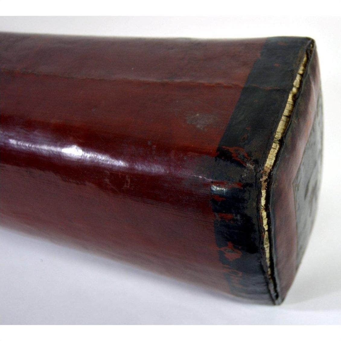 Close-up of a glossy red wooden rectangular opium pillow with black-edged end, shown against a plain background.