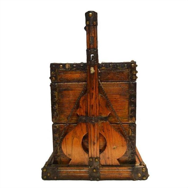 Brown wood and metal Chinese picnic box with iron reinforcements, shaped like a stringed instrument, close-up view.