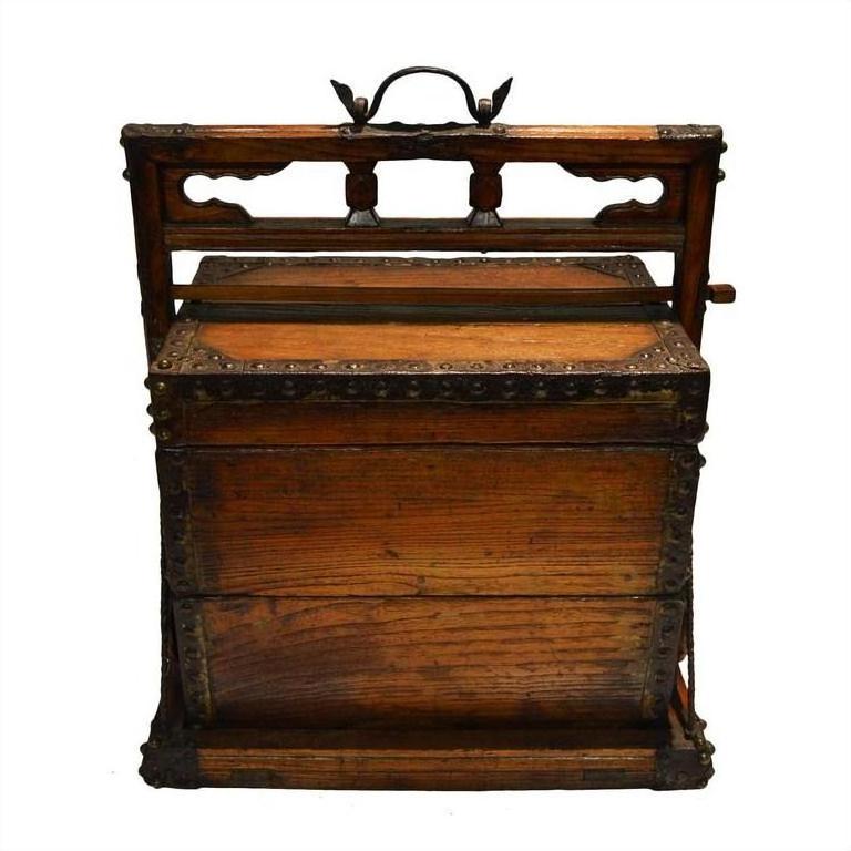 Brown wood and metal Chinese picnic box with handle and ornate front detailing, used for sewing or storage.