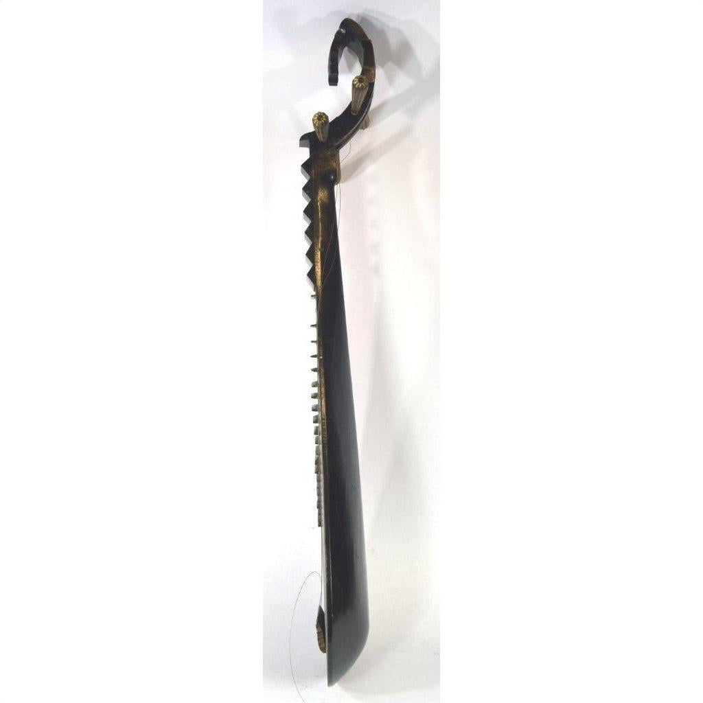 Dark carved wood Chinese PiPa lute with curved handle and jagged edge, close-up on white background.