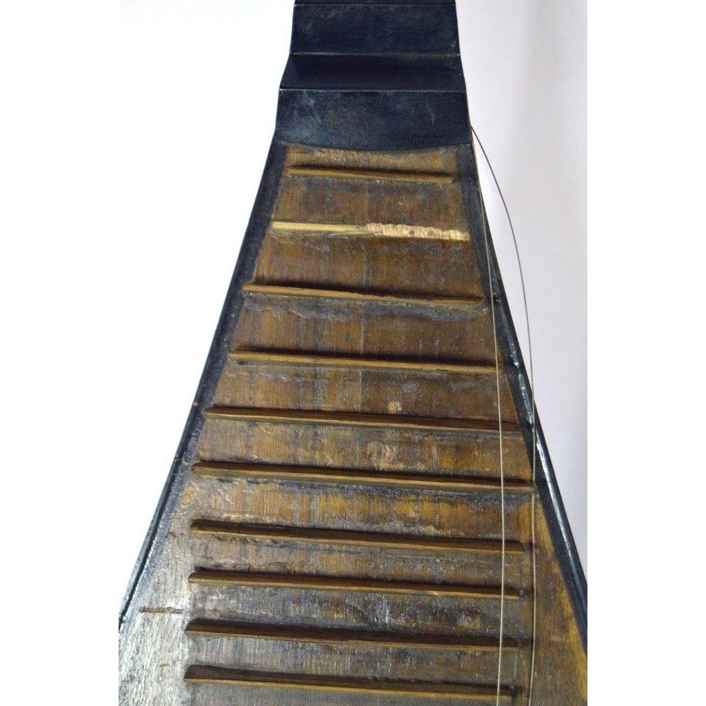 Close-up of a brown wooden Chinese PiPa lute with a damaged fret and loose wire string.