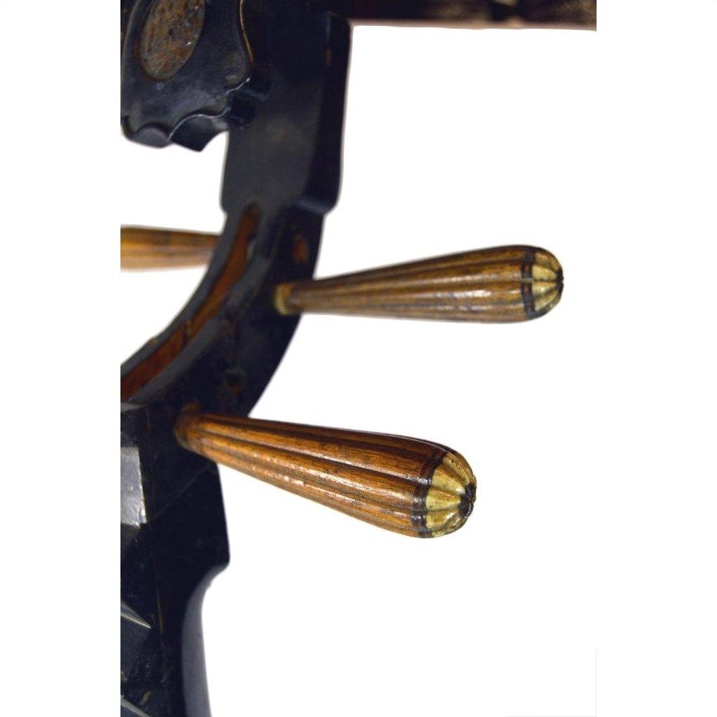 Close-up of three wooden pegs on a damaged wooden pegbox of a used Chinese PiPa Lute, set on a dark curved surface.
