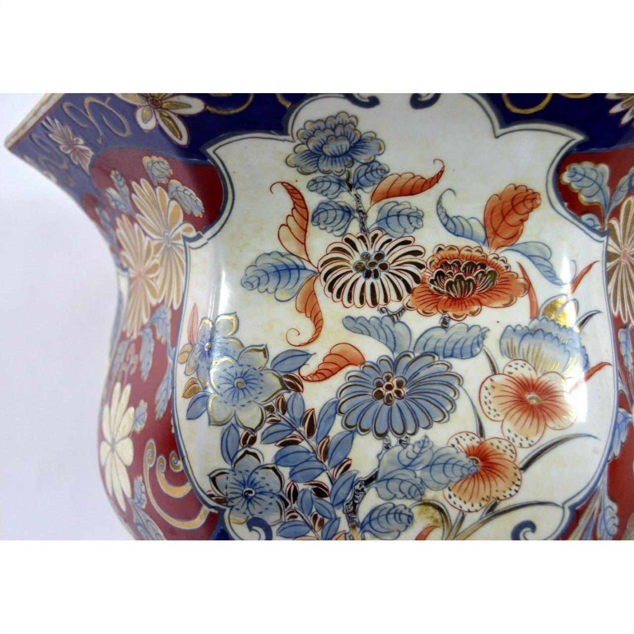 Close-up of a blue, red, gold, and cream Chinese porcelain planter with hand-painted floral patterns.