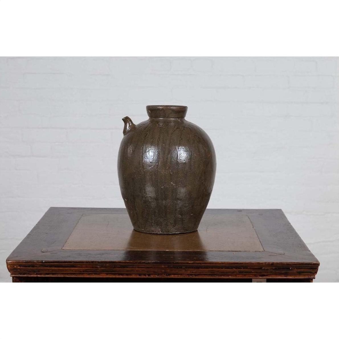 Glazed ceramic water jug with petite spout, Chinese Qing Dynasty, 19th century, on wooden table.