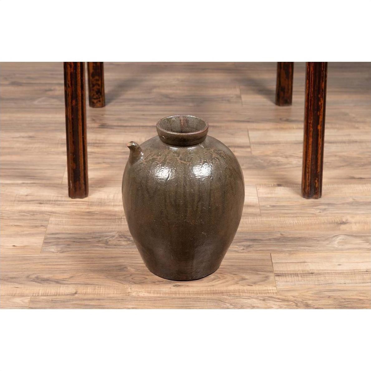 Glazed ceramic Chinese Qing Dynasty 19th-century water jug with petite spout on wooden floor under table.