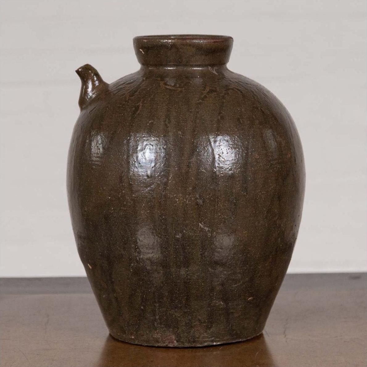 Glazed ceramic water jug with petite spout and rounded body, Qing Dynasty, 19th century, on plain background.