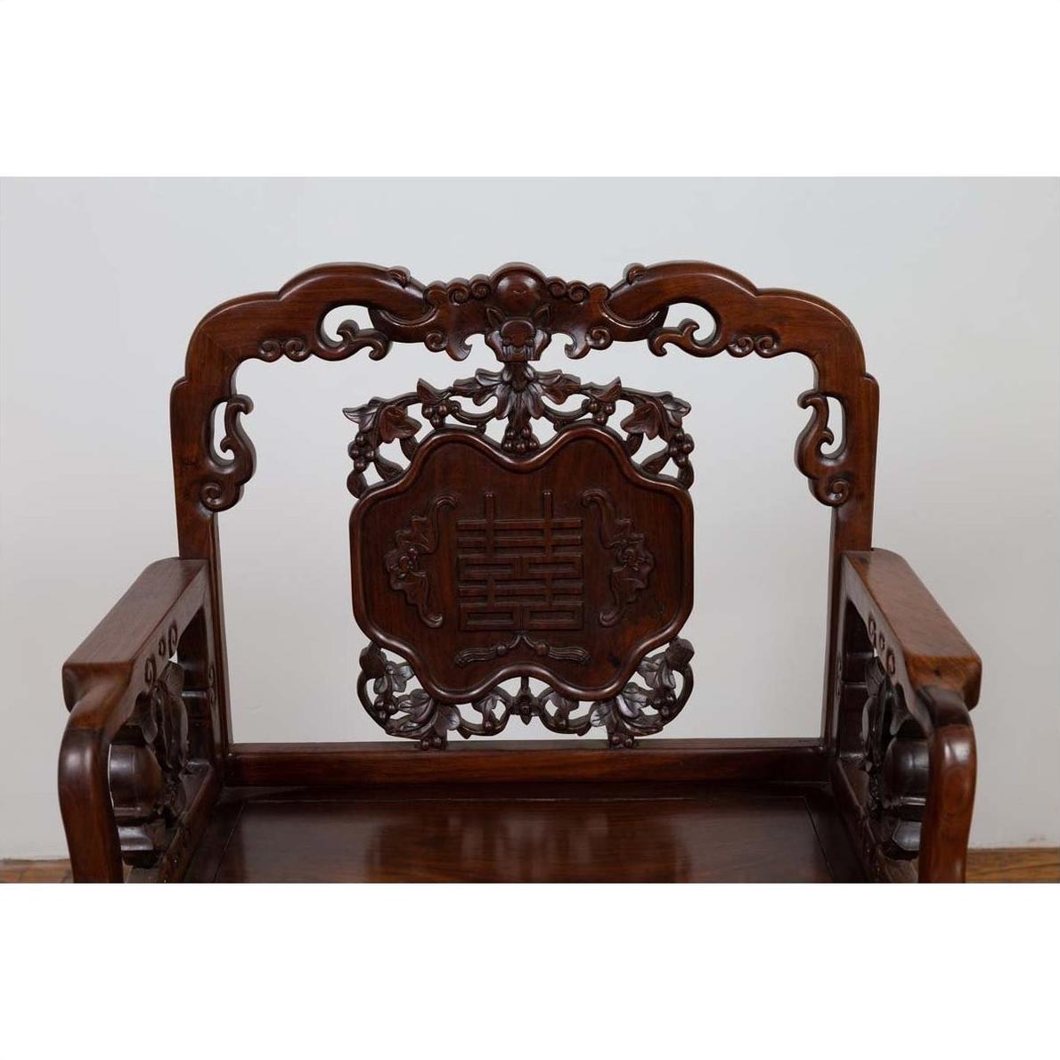 Dark rosewood Chinese chair with intricate 19th century hand-carved patterns, shown on plain white background.