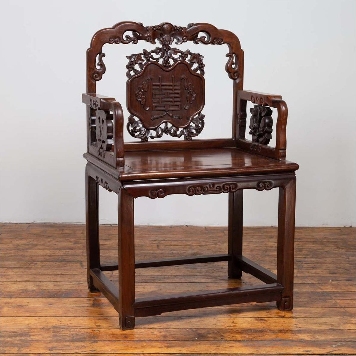 Dark rosewood Chinese chair with hand-carved details, 19th century, displayed on a wooden floor.