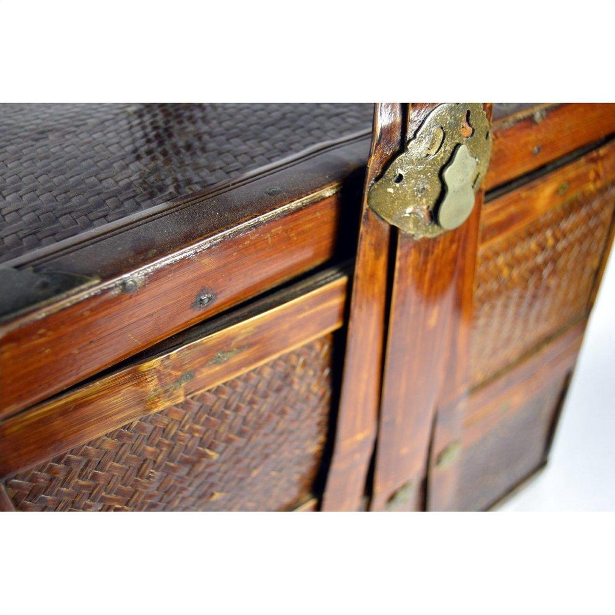 Close-up of a red wood Chinese Shandong wedding box with rattan panels and decorative brass lock.