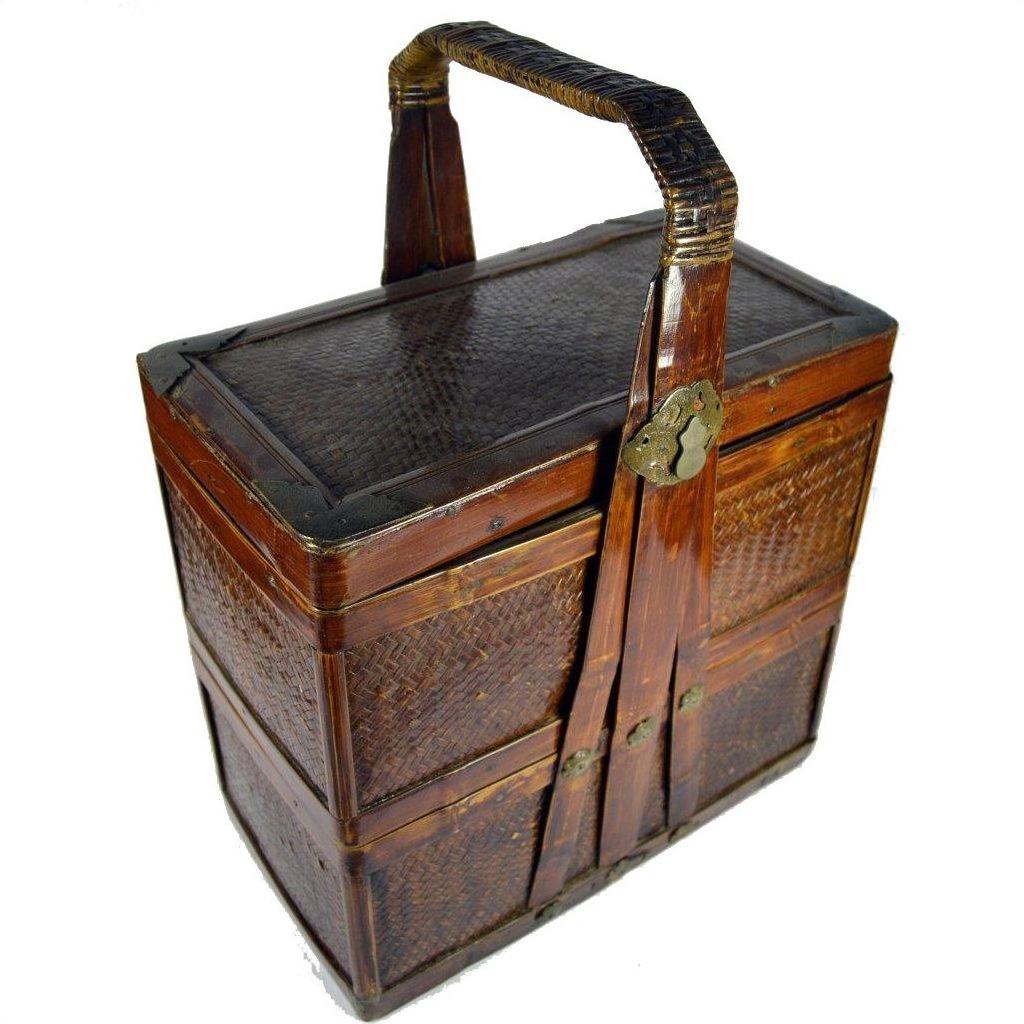 Brown bamboo and rattan rectangular wedding box with hinged handle and metal latch, close-up.