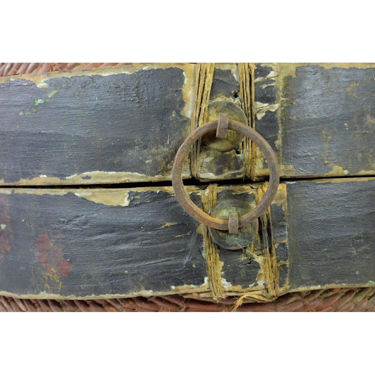 Close-up of weathered metal ring handle on painted wood Chinese storage basket with rattan twine detailing.