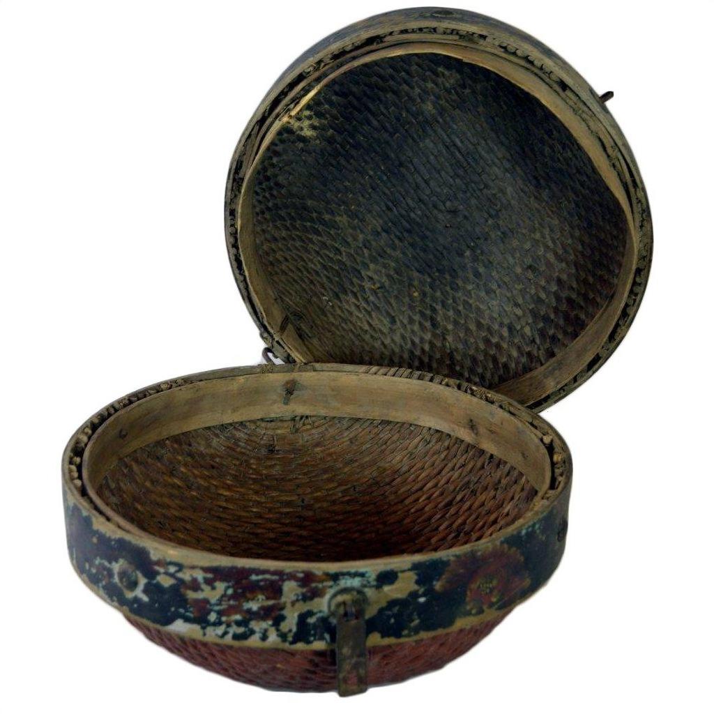 Brown rattan Chinese storage basket with hinged lid, textured interior, and worn exterior, close-up view.