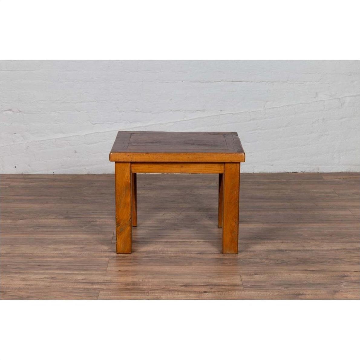 Natural wood Chinese vintage side table on wooden floor against white brick wall.