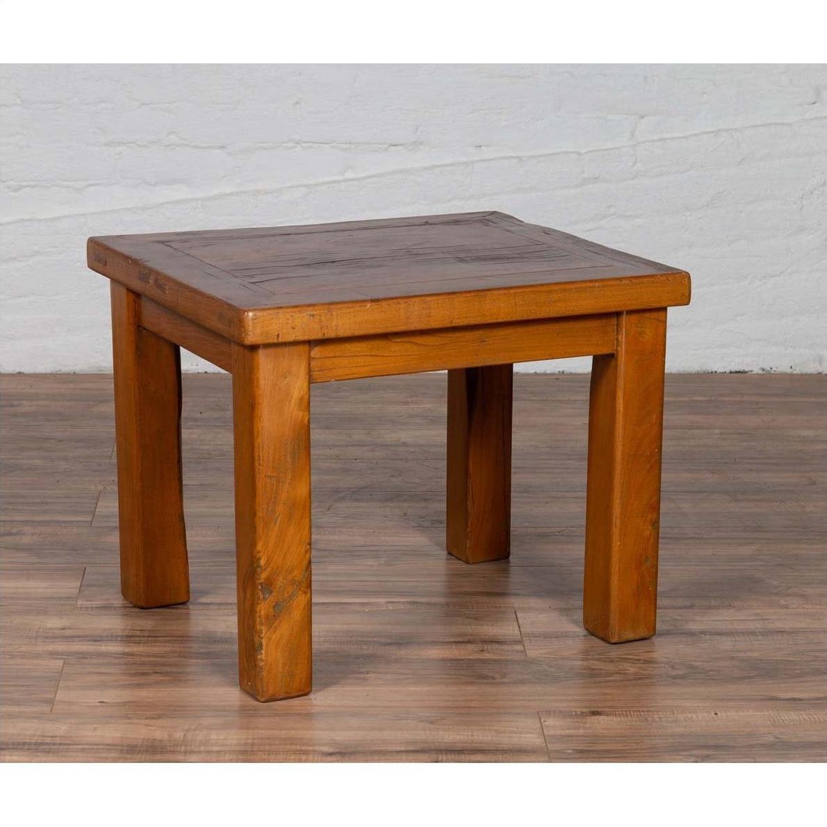 Natural wood Chinese vintage side table with thick legs on wooden floor, white brick wall background.